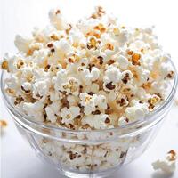 Freshly Popped Popcorn in a Clear Glass Bowl on a White Background for Snack and Food Themes photo