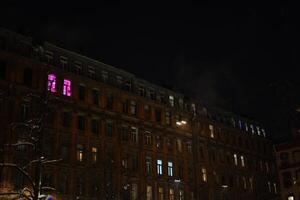 A stunning and captivating night view of a historic building adorned with colorful windows photo