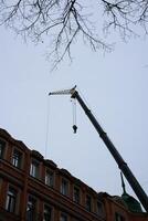 An Overhead Crane in Operation During a Building Renovation Project During the Daytime photo