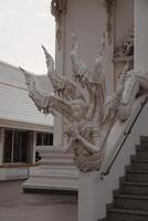 The Intricate and Exquisite Sculpture of a Deity at the Wat Rong Khun Temple in Thailand photo