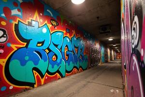 A graffiti covered tunnel with a light at the end photo