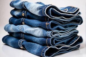 A stack of blue jeans on a white background photo