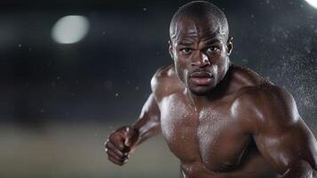 A muscular athlete sprints through pouring rain on a well-lit track, displaying focus and determination during a late-night training session. The atmosphere is charged with intensity and dedication photo