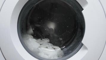 A washing machine filled with white laundry, in action. Utilizing modern technology and cleaning services to simplify household chores and maintain order video