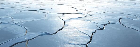 Cracked frozen surface with deep fractures in a vast winter landscape photo