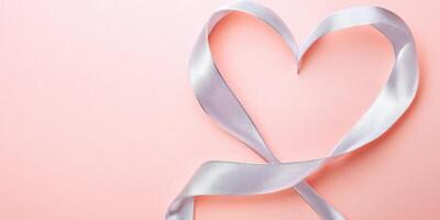 Pink ribbon forming a heart shape on soft background for love and romance concepts photo