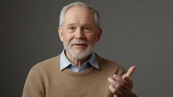 Elderly man with gray beard and warm smile reaching out, wearing a brown sweater photo