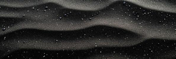 Rippling black sand and pebbles on desert dune landscape photo