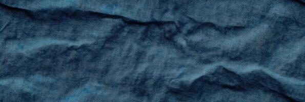 Crumpled blue denim texture fabric wrinkles textured background pattern close-up photo