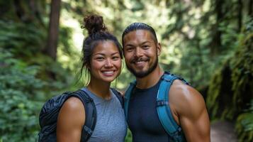 Happy couple hiking in forest with backpacks, smiling at camera in nature setting photo