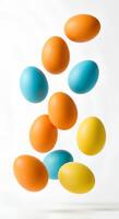colored easter eggs falling down on white background .Festive and vibrant eggs floating in the air for Easter designs. fun and festive design for Easter marketing and branding photo