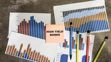 Concept of High Yield Bonds write on book isolated on Wooden Table. photo