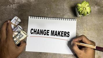 Concept of Change Makers write on book isolated on Wooden Table. photo