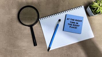 Concept of At The Right Time In The Right Place write on sticky notes isolated on Wooden Table. photo