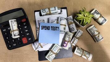 Concept of Spend Test write on sticky notes isolated on Wooden Table. photo