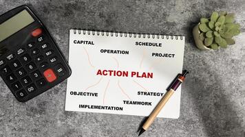Concept of Action Plan write on book with keywords isolated on Wooden Table. photo