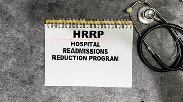 Concept of HRRP - Hospital Readmissions Reduction Program write on book isolated on Wooden Table. photo