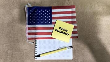 Concept of Open Primary write on sticky notes and Flag of the United States isolated on Wooden Table. photo