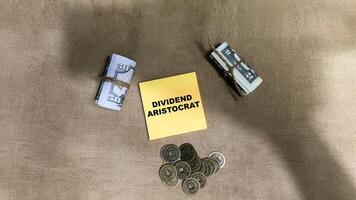 Concept of Dividend Aristrocrat write on sticky notes isolated on Wooden Table. photo