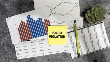 Concept of Policy Violation write on sticky notes isolated on Wooden Table. photo