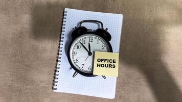 Concept of Office Hours write on sticky notes isolated on Wooden Table. photo
