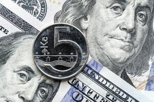 A five dollar coin is sitting on top of a stack of us dollars photo