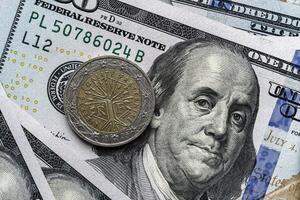 A close up of a one dollar coin and a hundred dollar bill photo