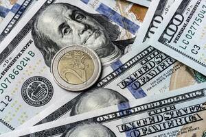 A one dollar coin is sitting on top of a pile of us dollars photo