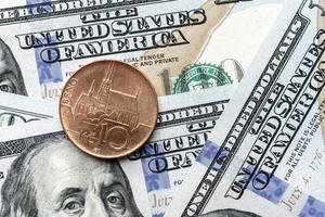 A one cent coin is sitting on top of a pile of us dollars photo