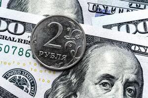 A close up of a russian coin and a hundred dollar bill photo