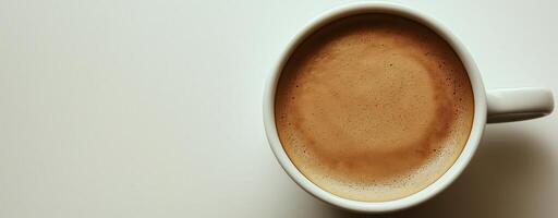 Top view of a cup of aromatic coffee with rich crema on white background, copy space photo