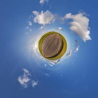 A small planet with a field and clouds photo