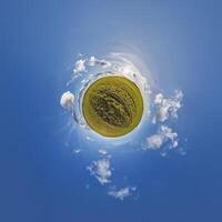 A small planet with a grassy field and clouds photo