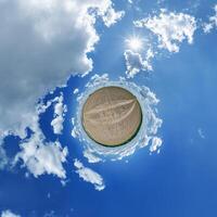 A small planet with clouds and sun in the sky photo