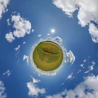 A small planet with grass and clouds photo