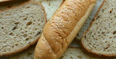 Bread cut into slices and a long bun on them photo