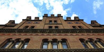 Facade Of Ancient Brick Castle Tower On Cloudy Sky Bottom View photo