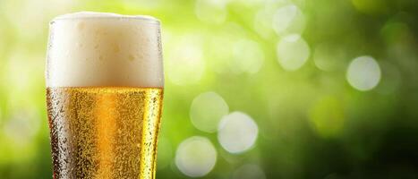 Refreshing glass of beer against a lush green background nature, copy space photo