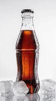 Chilled cola bottle with ice cubes studio beverage photography minimalist close-up refreshing concept photo