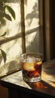 Refreshing cola with ice in a vintage glass natural light setting artistic photography photo