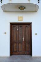 Classic wooden door framed by simple architecture invites exploration on a bright sunny day photo