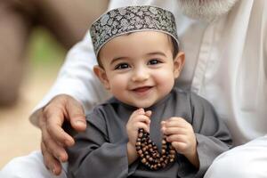 A little boy wearing a turban and holding a rosary photo