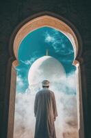 Man in white standing in front of mosque photo