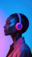 A woman wearing headphones in front of a neon background photo