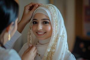 A woman in a white hijab is getting ready to put on her head photo