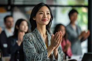 Asian woman clapping at business meeting photo