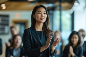 A businesswoman clapping in front of a group of people photo