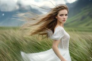 A beautiful young woman in a white dress is running through a field photo