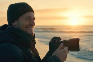 A man is holding a camera while standing on the beach photo
