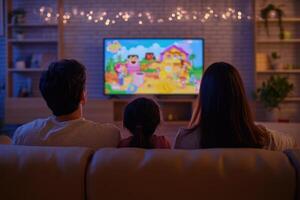 A family sitting on a couch watching tv photo
